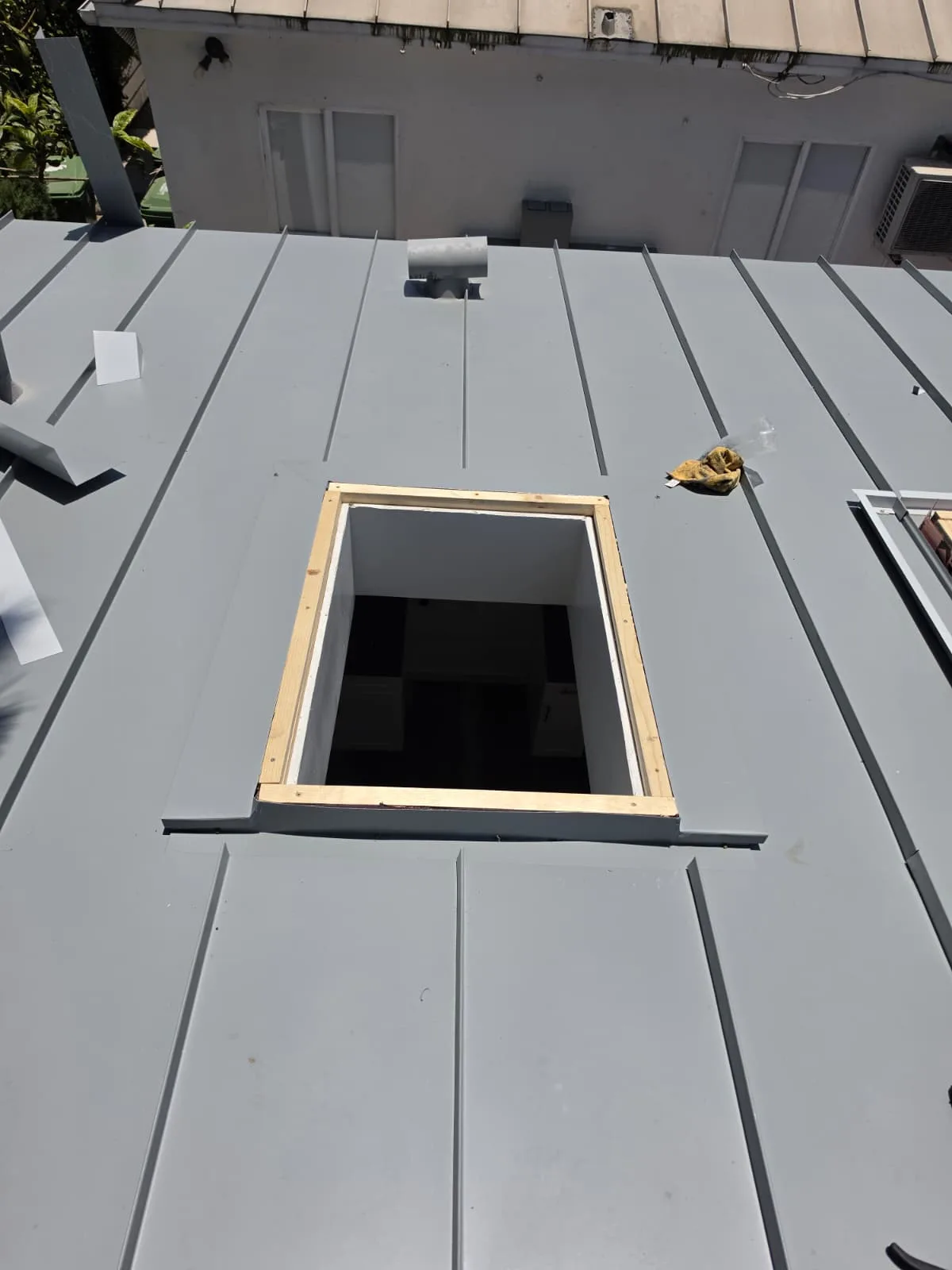 Curb framing prepped for a new skylight opening in a standing seam metal roof panel