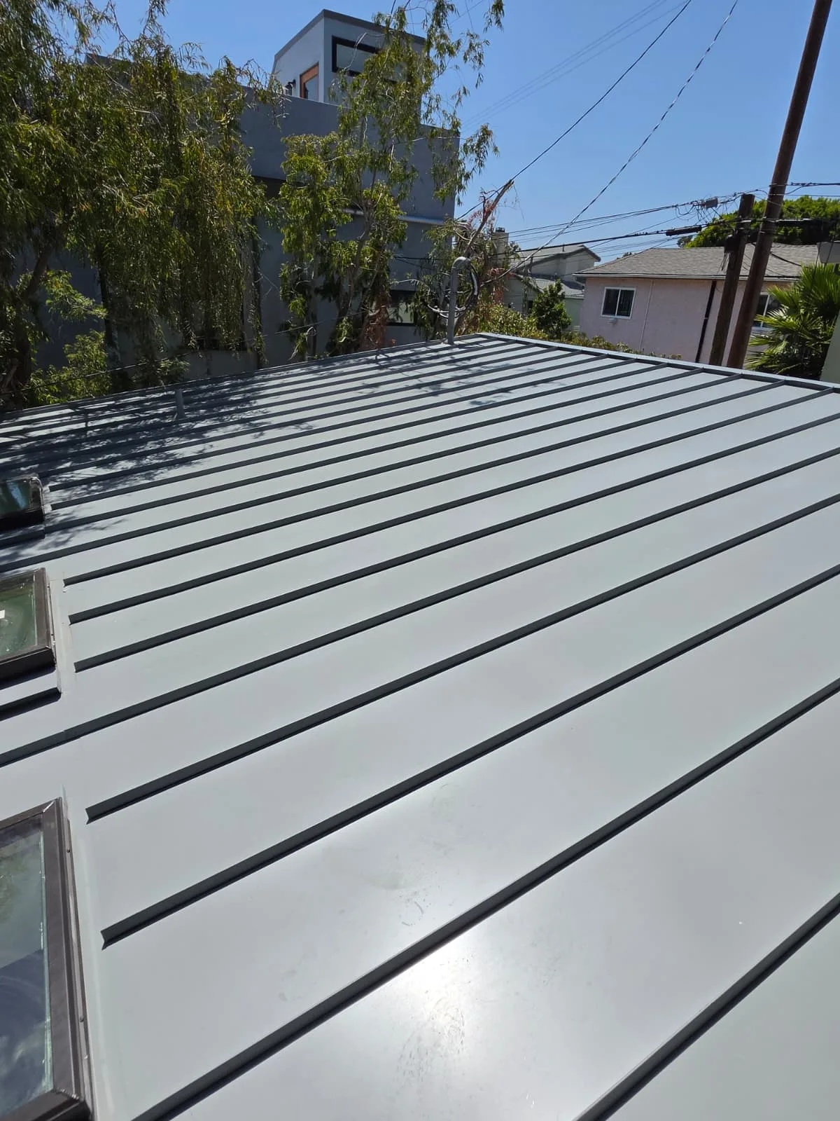Completed standing seam metal roof installation viewed along the panel runs