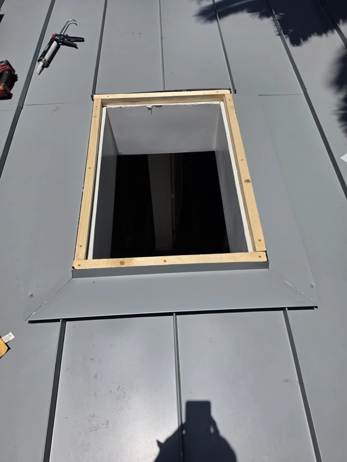 Close-up of a metal roof skylight curb with custom sheet metal head flashing