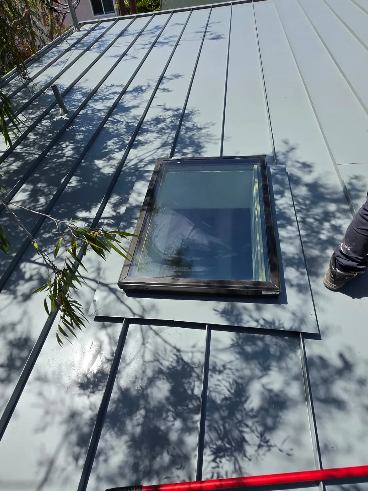 Finished skylight set into a standing seam metal roof with clean panel seams