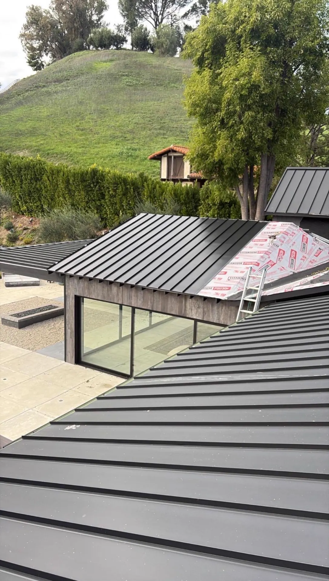 Two standing seam metal roof structures completed on a hillside estate property in California