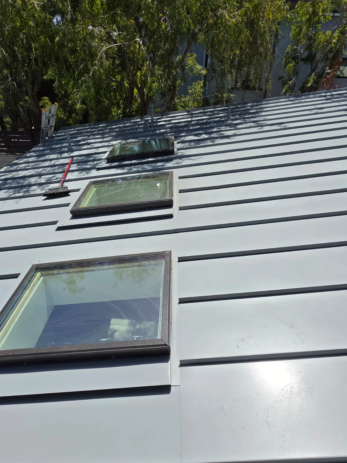 Standing seam metal roof with three newly flashed skylights installed by California First Roofing in San Jose